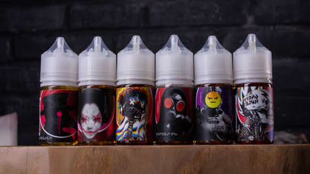 Ufa, Russia, Vape Shop, 3 July, 2019: E-liquid e-juice High vape for electronic cigarette vaping device , on counter in smoke vapor in vape bar in bottles.のeditorial素材