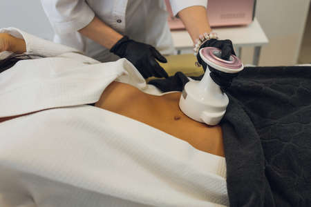 Woman in special white suit getting anti cellulite massage in a spa salon. LPG, and body contouring treatment in clinic.の写真素材