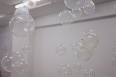 White And Transparent Balloons On Brick Wall Background.