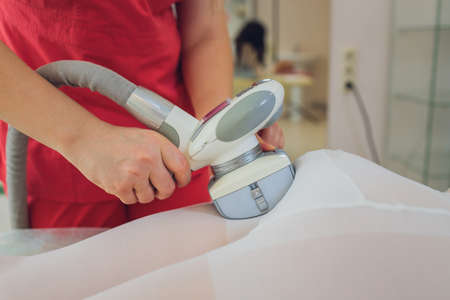 Woman in special white suit getting anti cellulite massage in a spa salon. LPG, and body contouring treatment in clinic.の写真素材