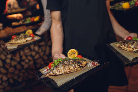 Dorado on grill on the board on wooden table.の写真素材