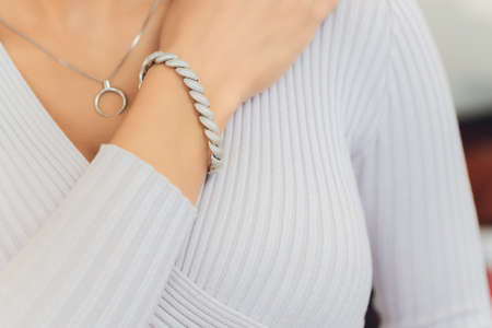 Womans hands with perfect manicure with silver bracelet.