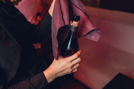 opening stages unscrewing the wire from a champagne bottle.の写真素材