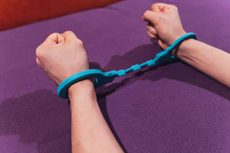 male and female hand in handcuffs. couple in bed. sex Toys.の写真素材