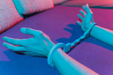 male and female hand in handcuffs. couple in bed. sex Toys.