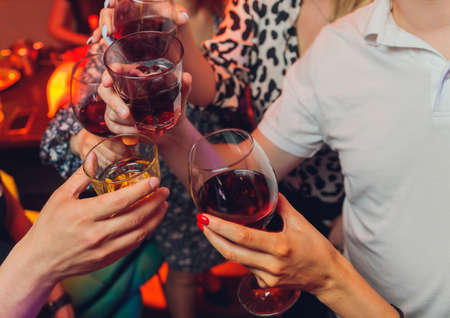 Clinking glasses with alcohol and toasting, party.