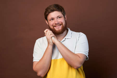man with emotions on his face with a beard on a brown background, logo, copy space.