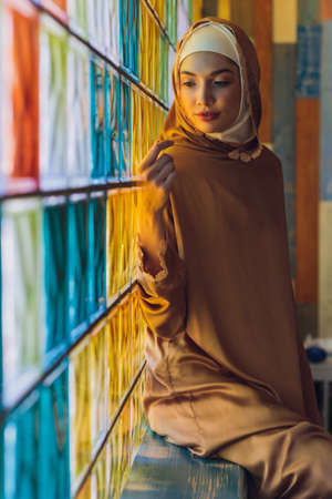Arabian young muslim woman sitting in a cafe.の写真素材