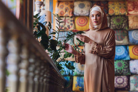 Arabian young muslim woman sitting in a cafe.の写真素材