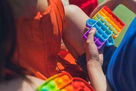 Anonymous child hold in his hands sensory toy and shows it in front of himself.Rainbow color.Antistress toy for children and adult.の写真素材
