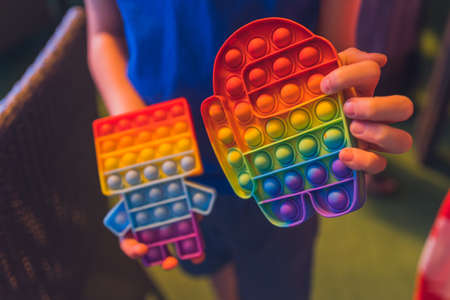 Anonymous child hold in his hands sensory toy  and shows it in front of himself.Rainbow color.Antistress toy for children and adult.の写真素材