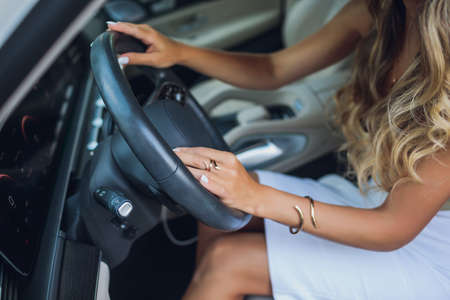 Close-up of a womans hand on steering wheel in a modern car.の写真素材
