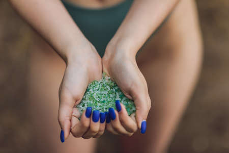 Tiny pieces of plastic collected from sandy beach in hands of environmentalist. Microplastic is polluting the sea and marine ecosystem.の写真素材