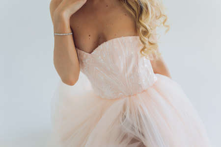 Charming bridesmaid dress with a delicate bow, rhinestones, embroidery and shiny beads close-up.の写真素材