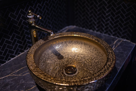 Vintage Beautiful faucet and golden mixer tap on a marble round sink in the bathroom. Interior of an expensive toilet with a marble sink.の写真素材