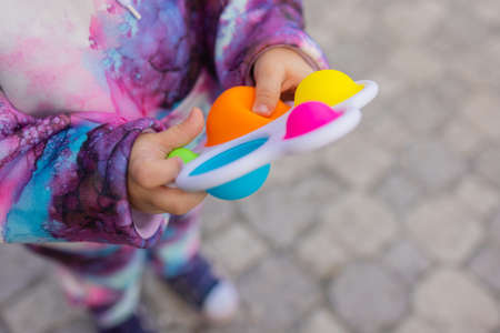 fidget toy in girl hands. Colorful antistress kids toy fidget.の写真素材