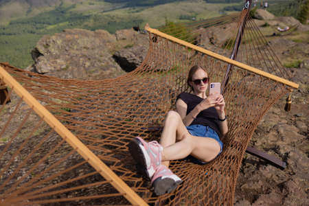 Young adult happy short haired shaved bald attractive woman chilling enjoy relaxing sitting in...