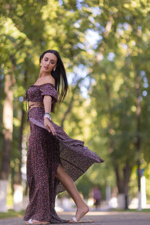 beautiful young woman in glasses in the park on a background of greenery.の写真素材