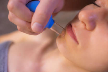 Woman receives facial cupping massage facial rejuvenation at acupuncture wellness spa.