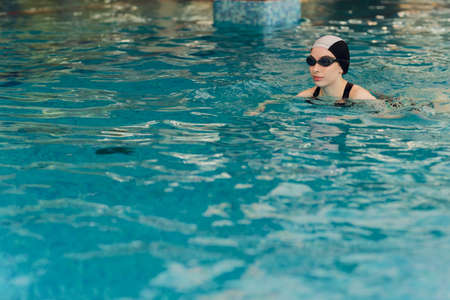 Professional female swimmer training in a swimming pool.の写真素材