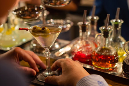 martini with green olives on a table in barの写真素材
