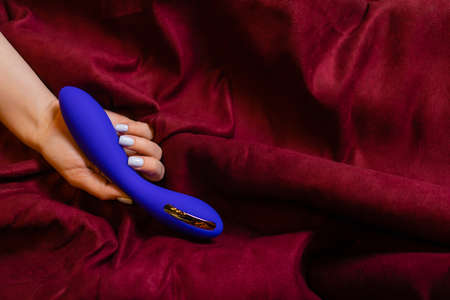 Woman in bedroom holding vibrator in hand.の写真素材