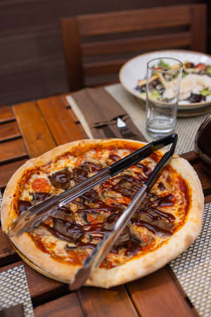Italian pizza with prosciutto tomatoes olives olive oil parmesan cheese and arugula. Blurred...