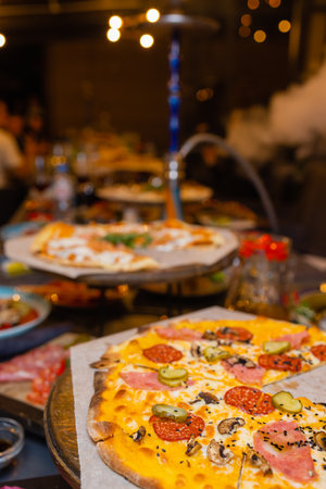 Hot pizza slice with melting cheese on a rustic wooden table.の写真素材