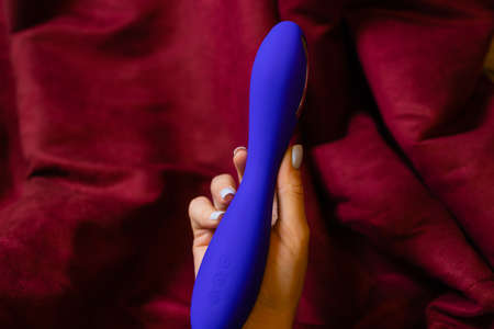 Woman in bedroom holding vibrator in hand.の写真素材