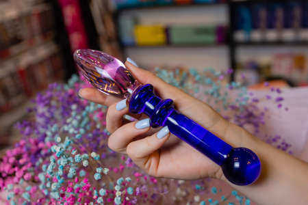 Anal glass butt plug with a fluffy tail with female hands. Toy for adult games.の写真素材