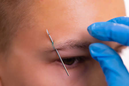Man with pierced eyebrow. Three small black piercings.の写真素材