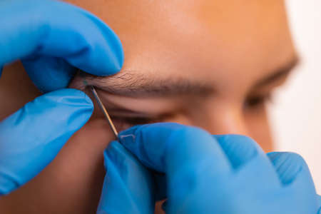 Man with pierced eyebrow. Three small black piercings.の写真素材