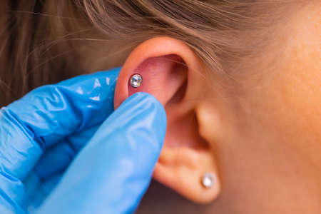 Professional holding the jewel of piercing just before screw the ball.の写真素材