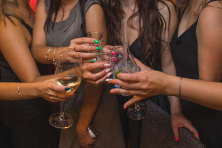Clinking glasses with alcohol and toasting, party.の写真素材