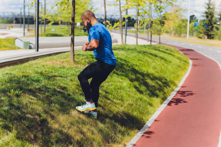 Young athlete running fast outdoors. Wearing sport cloth, doing wide step, demonstrating healthy way...