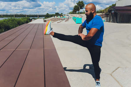 Young athlete running fast outdoors. Wearing sport cloth, doing wide step, demonstrating healthy way...