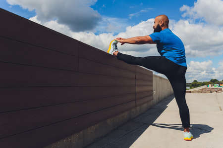Young athlete running fast outdoors. Wearing sport cloth, doing wide step, demonstrating healthy way...