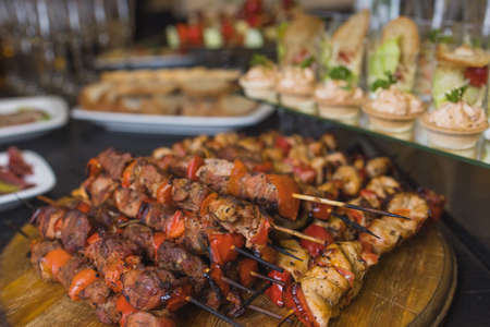 Assorted meat on a plate close up. Different types of meat and potatoes in a heap. Appetizer on a large plate with sauces.の写真素材