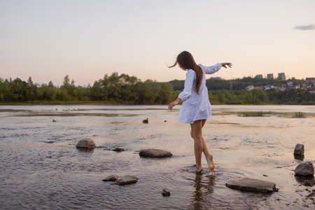 Outdoors fashion photo of beautiful bohemian lady at river.の写真素材