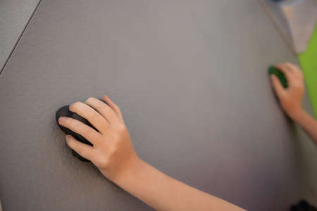 Yellow climbing wall with colorful rocks playground.の写真素材