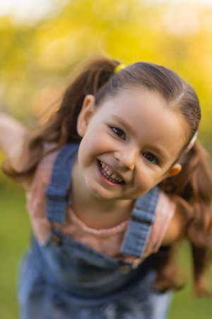 Baby toddler running on green lawn near the house.の写真素材