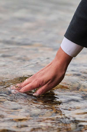 Womans hand on the mattress touch water.の写真素材