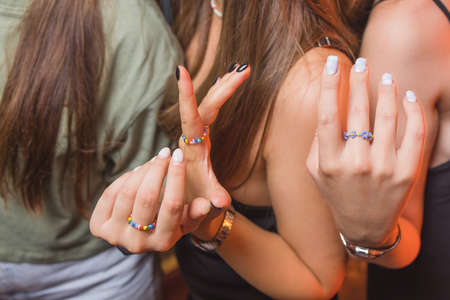 close-up view of a mans hand showing a ring with an LGBT rainbow wristband.の写真素材