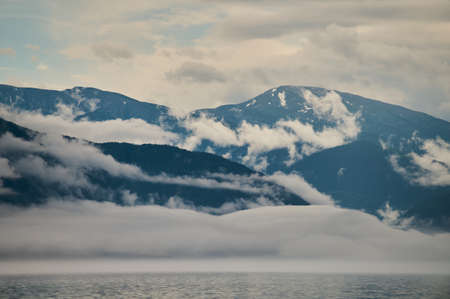 Fog in the mountain valley. Morning fog over the lake in the Altai mountains.の写真素材