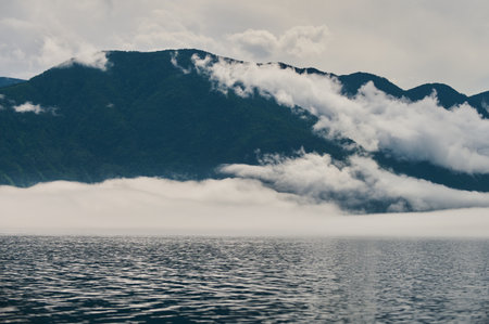 Fog in the mountain valley. Morning fog over the lake in the Altai mountains.