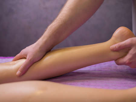 relaxing pain. fabulous full foot massage.close up side view cropped photo.の写真素材