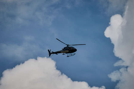 Helicopter flying in the blue sky with sun.の写真素材