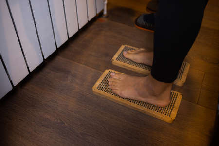 practice of standing on nails. Close-up of a yoga man standing on a sadhu board with sharp nails. Wooden sadhu board with nails for sadhu practice.の写真素材