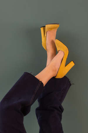 Woman in stylish shoes on yellow background.の写真素材
