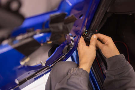 Auto repair technicians in car repair shops are repairing car door systems and repairing electric vehicle systems.の写真素材